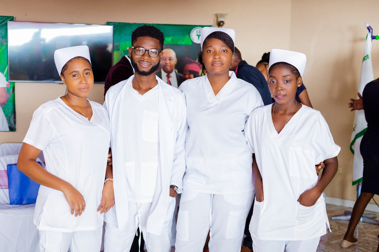 contact-img Four healthcare professionals wearing white uniforms, posing indoors.