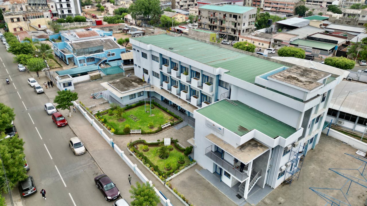 hero-img-01 Aerial view of a modern building and street in Tete, Mozambique, showcasing urban architecture.