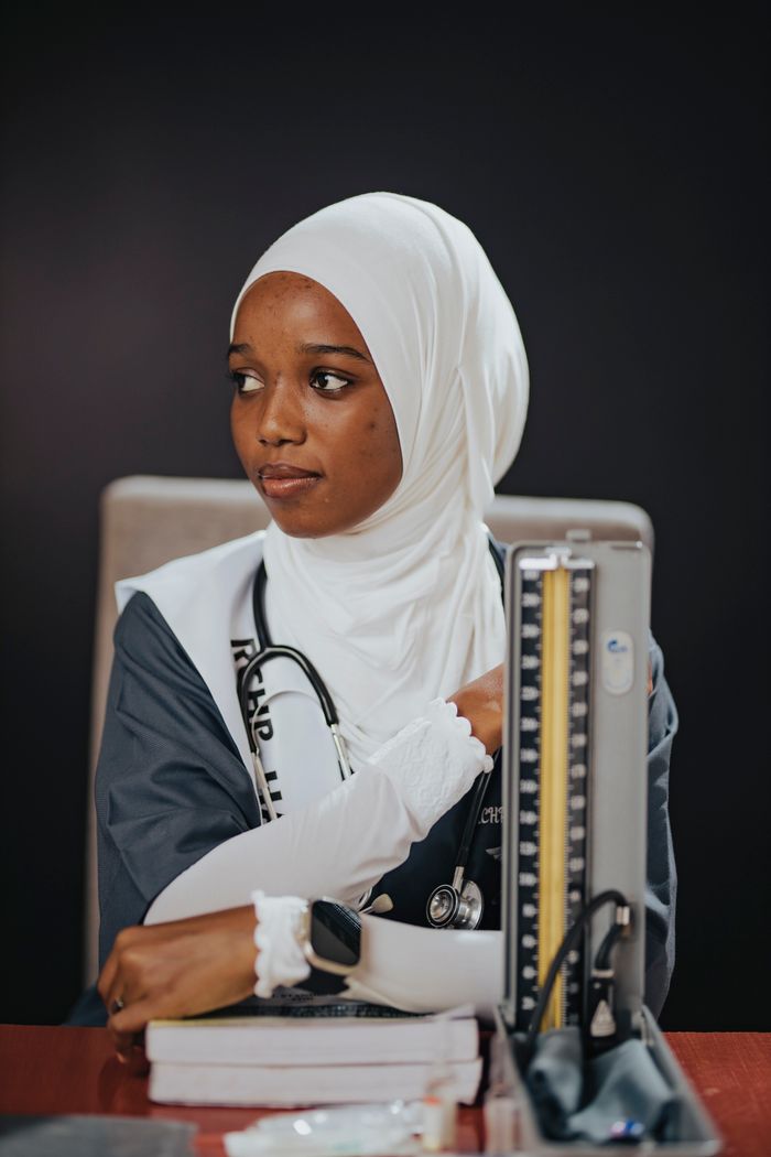 services-03 Confident young doctor wearing hijab with medical tools in modern workspace.